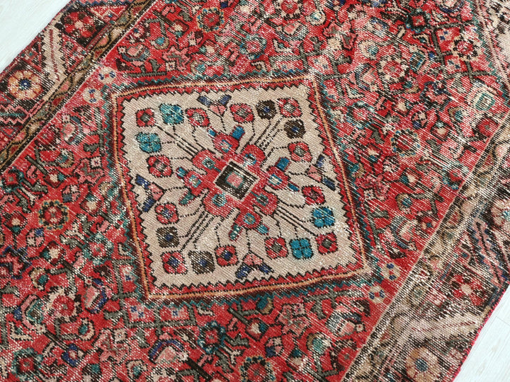 a red rug with a floral design on it