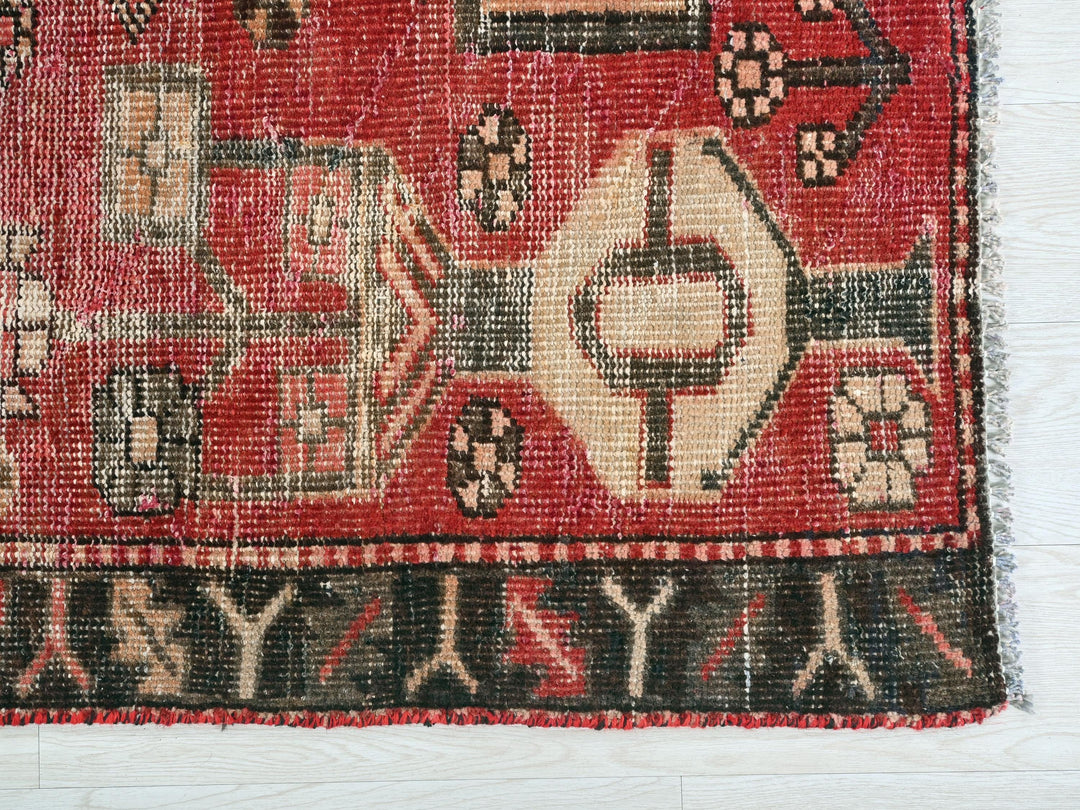 a red rug with a picture of a house on it