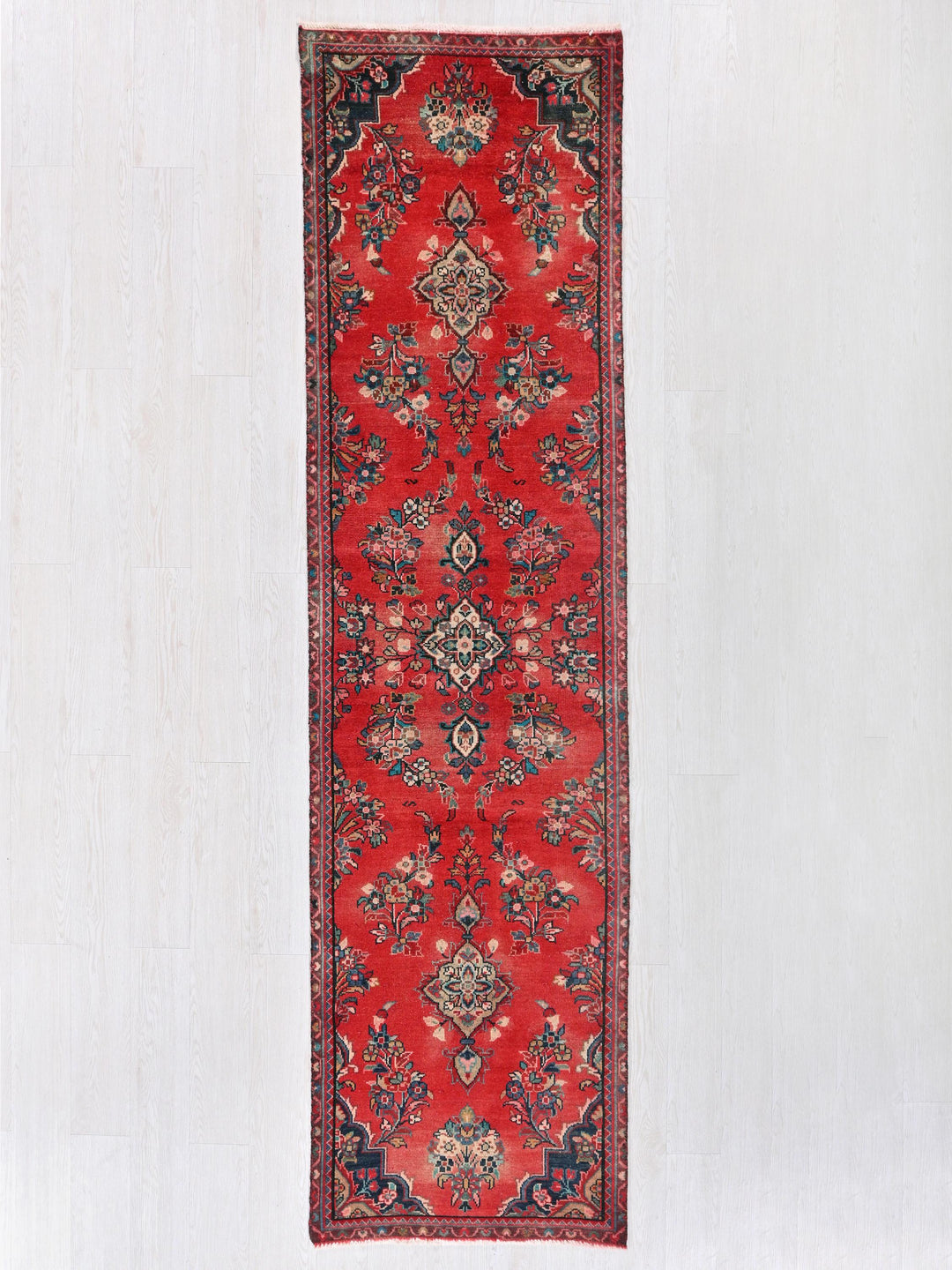 a red rug hanging up against a white wall