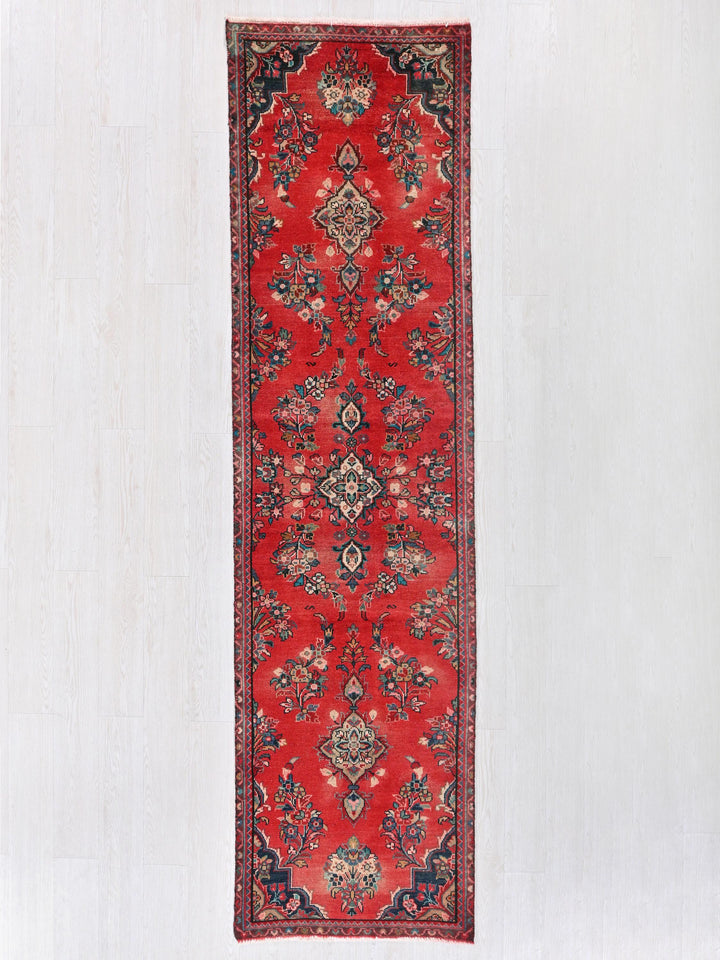 a red rug hanging up against a white wall