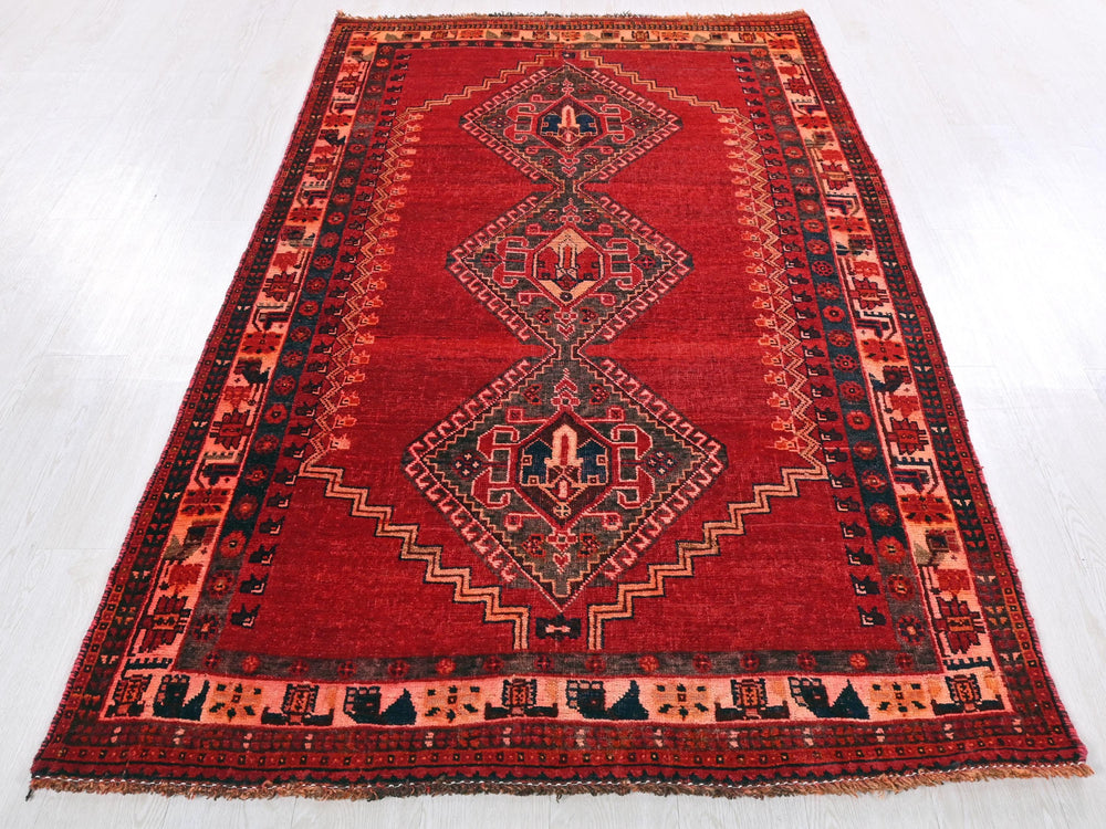 a red rug with a diamond design on it