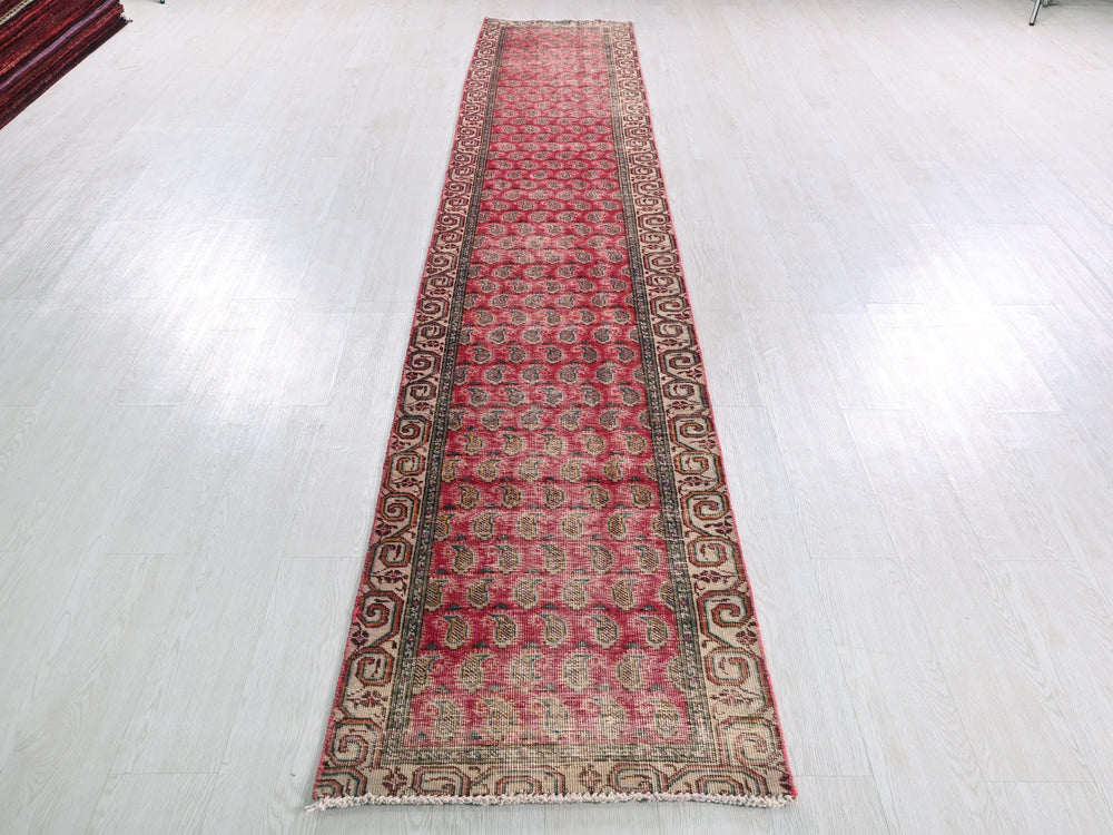 a long red rug sitting on top of a white floor