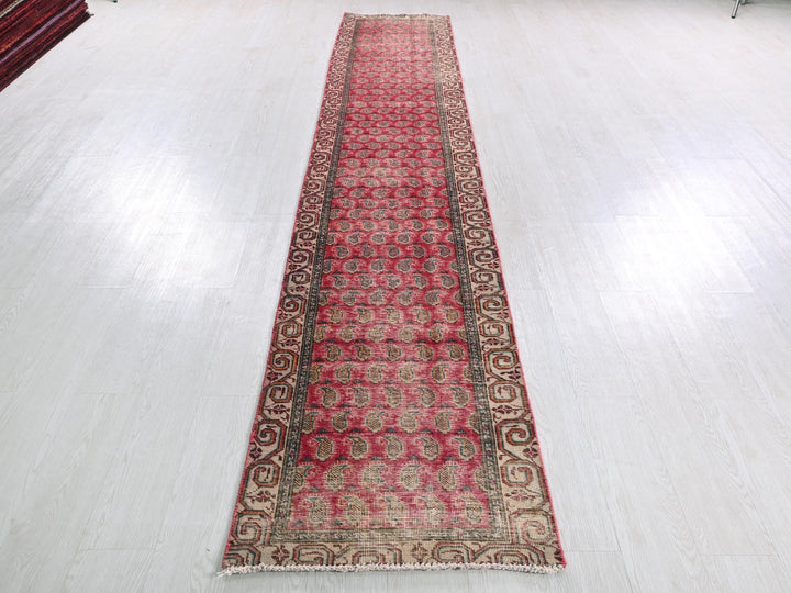a long red rug sitting on top of a white floor