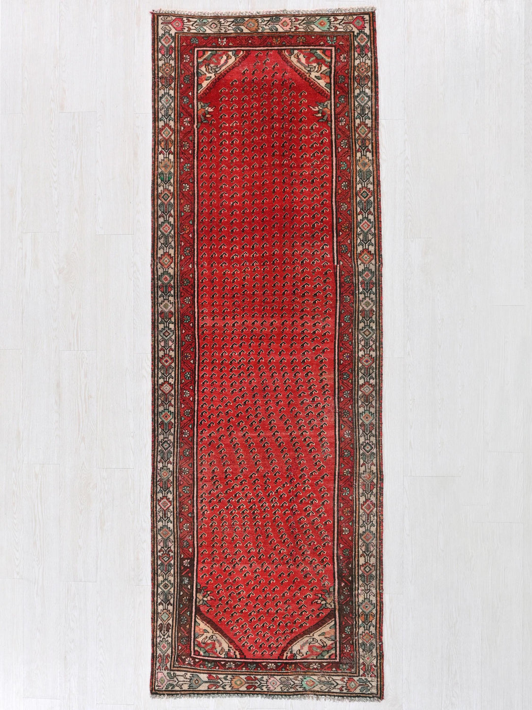 a red rug hanging on a white wall