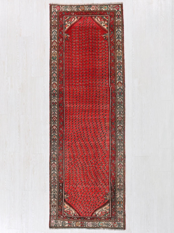 a red rug hanging on a white wall