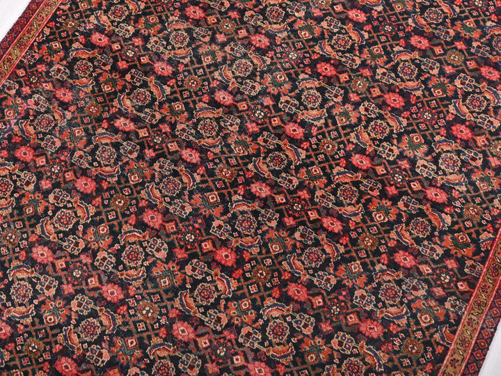 a red and black oriental rug on a white floor