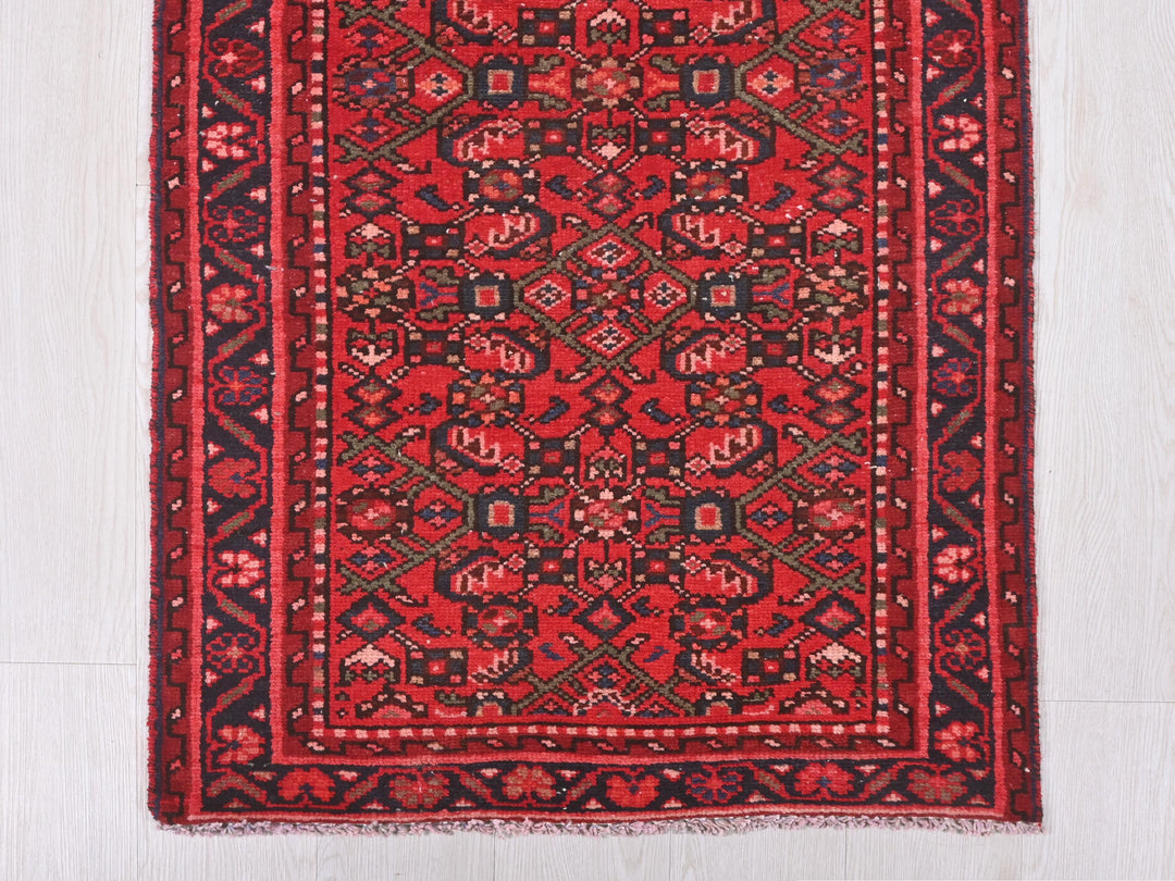 a red and black rug on a white floor
