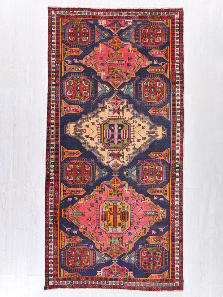 a multicolored rug hanging on a wall