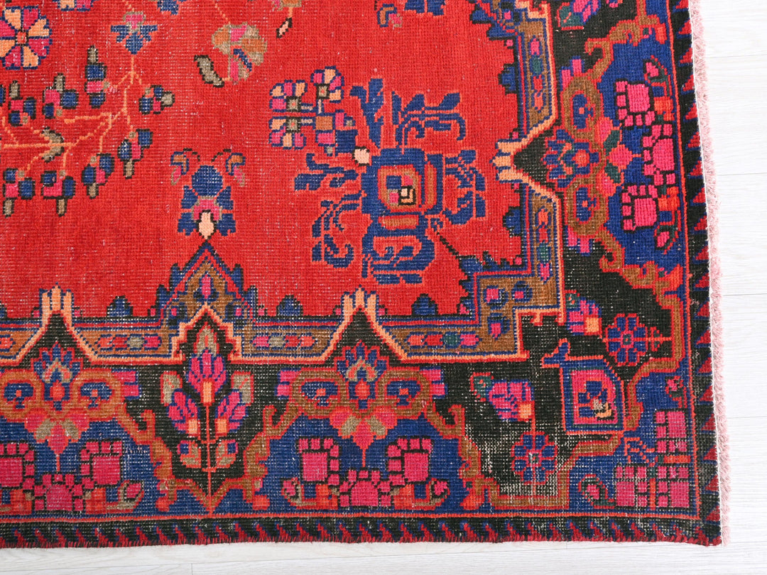 a red rug with a blue and pink design on it