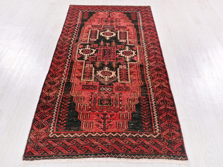 a red and black rug on a white floor