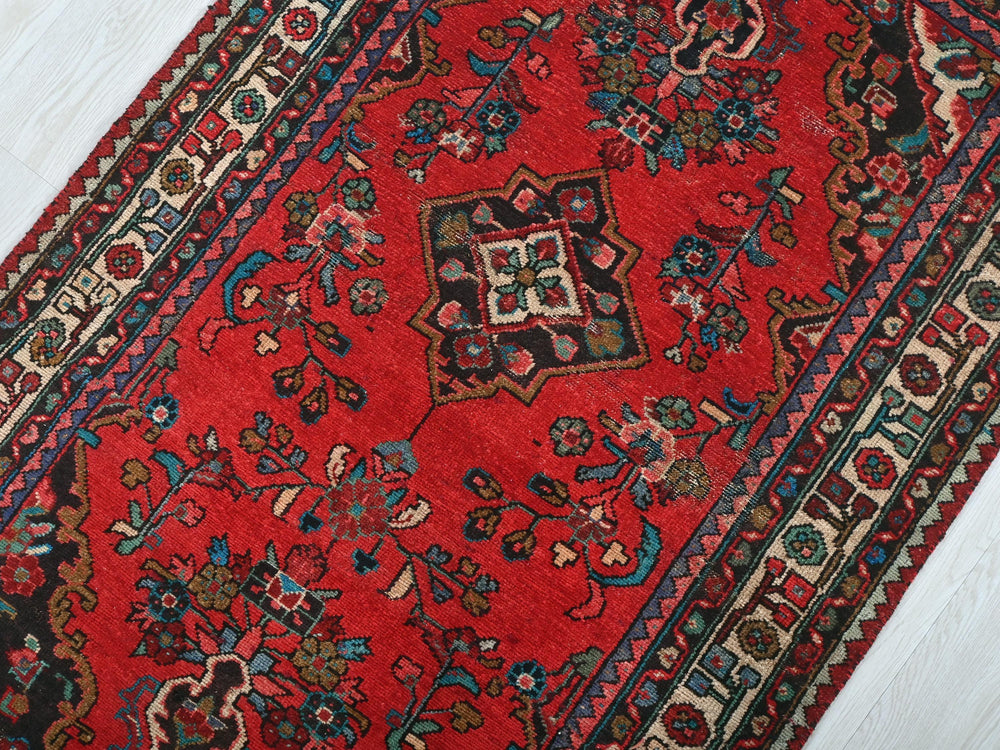 a red rug on a white wooden floor