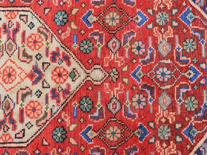 a red rug with a diamond shaped design on it