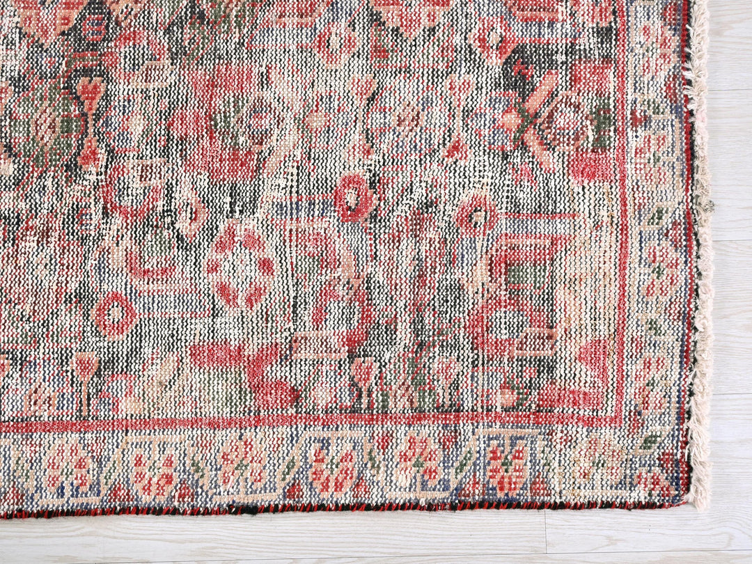 a red and blue rug on a white wooden floor