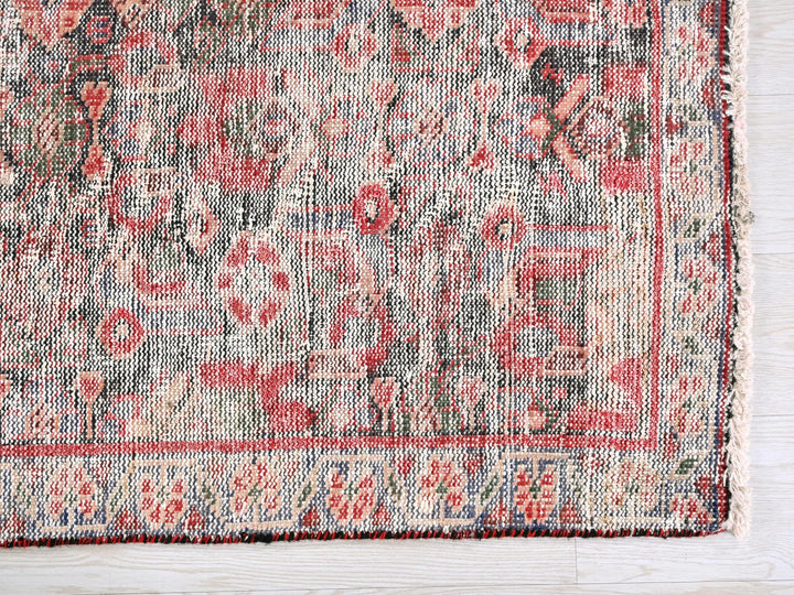 a red and blue rug on a white wooden floor