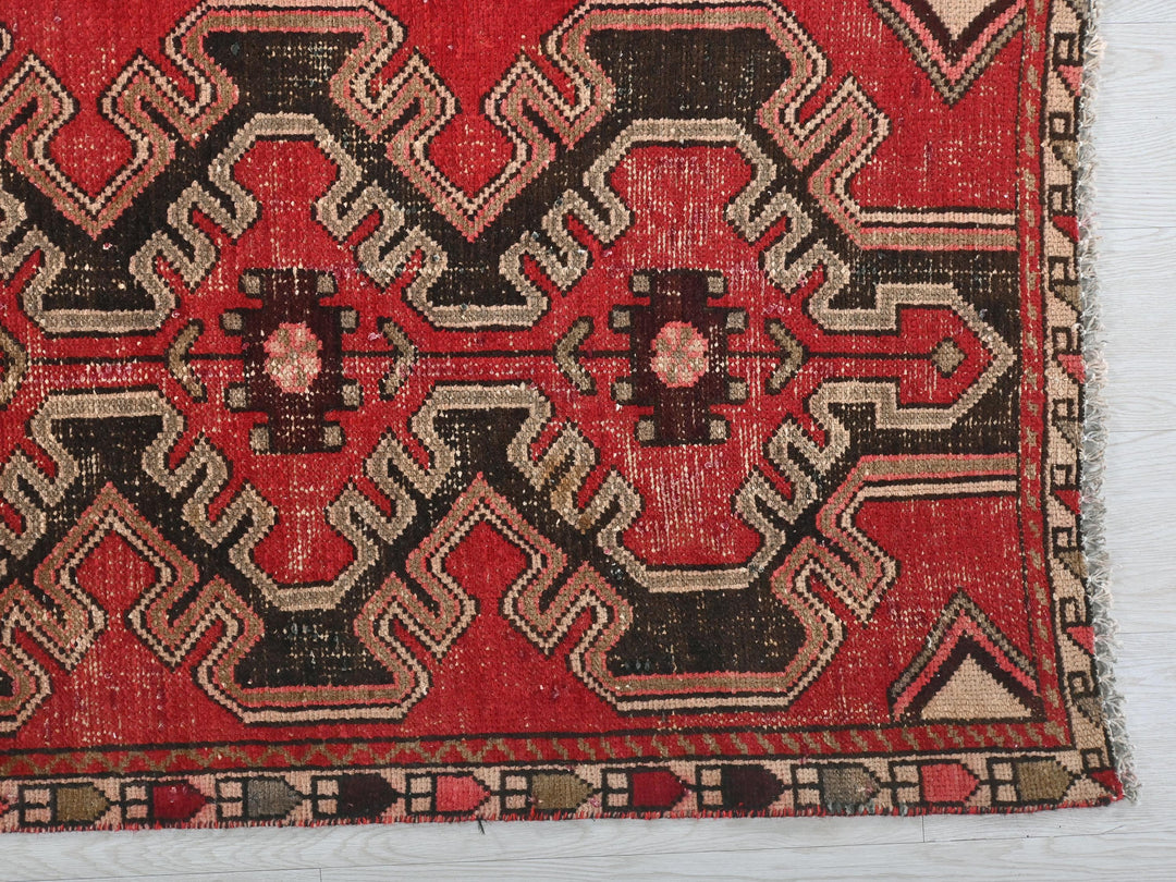 a red rug with a design on it