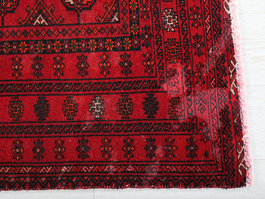 a close up of a red rug on a wooden floor