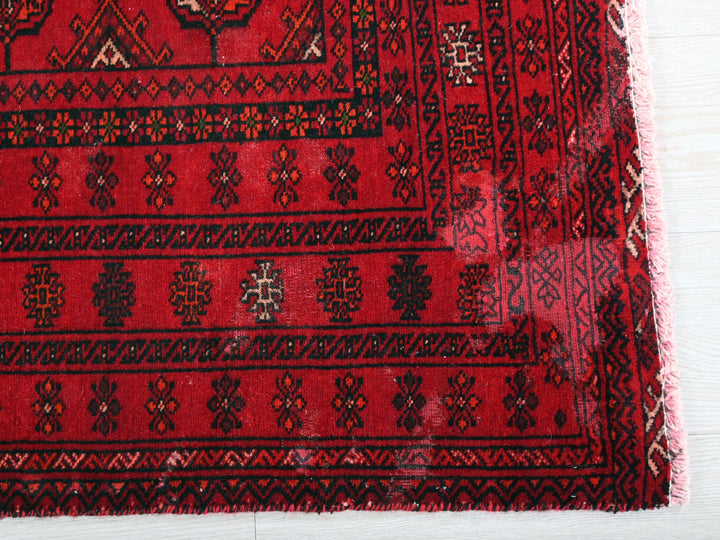 a close up of a red rug on a wooden floor