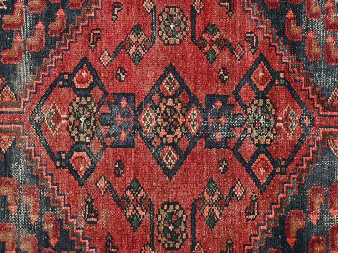 a red rug with a diamond pattern on it