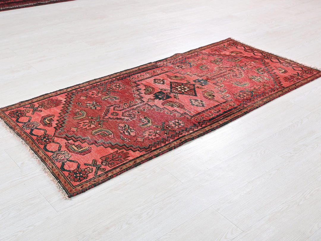 a red rug is laying on a white floor