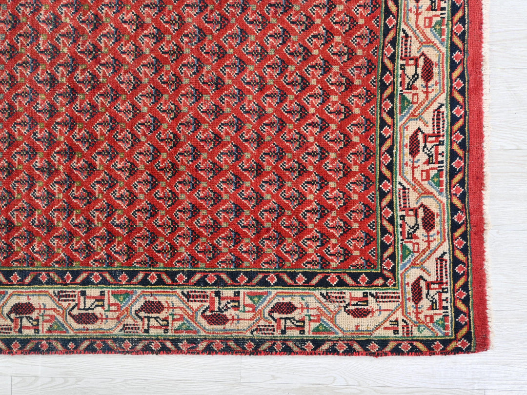 a red and black rug on a white surface