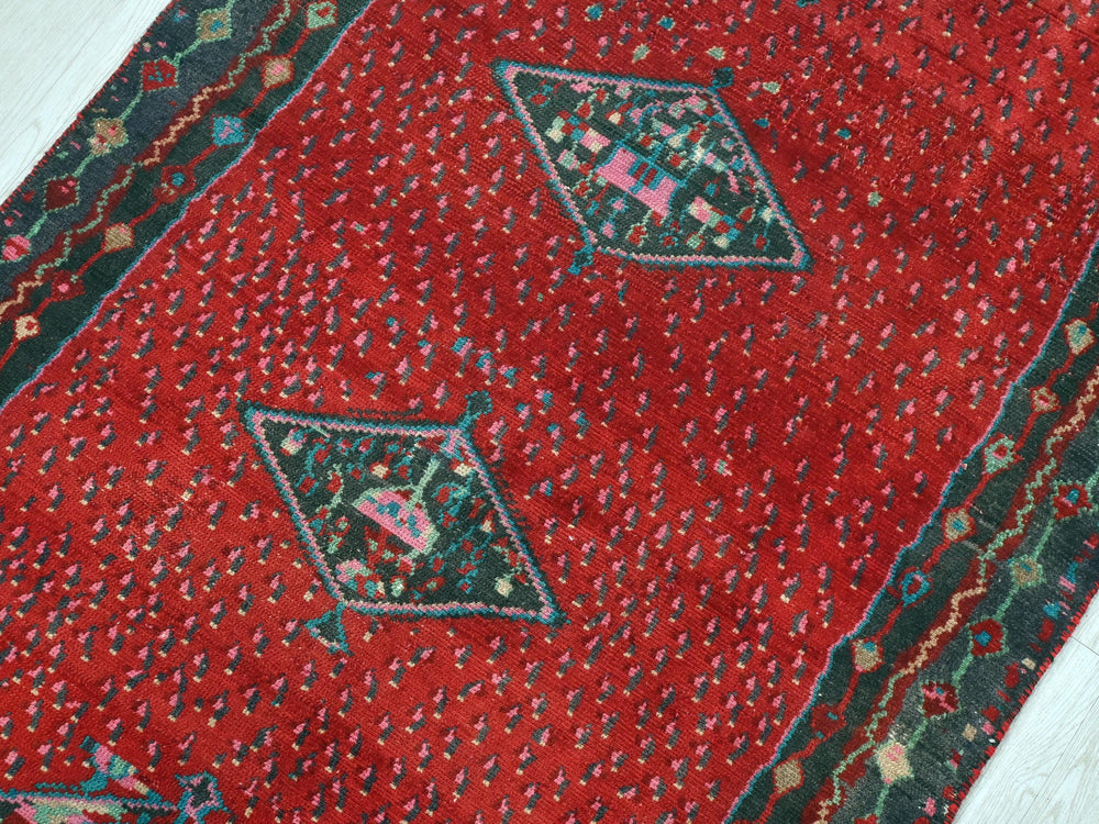 a close up of a red rug on a wooden floor