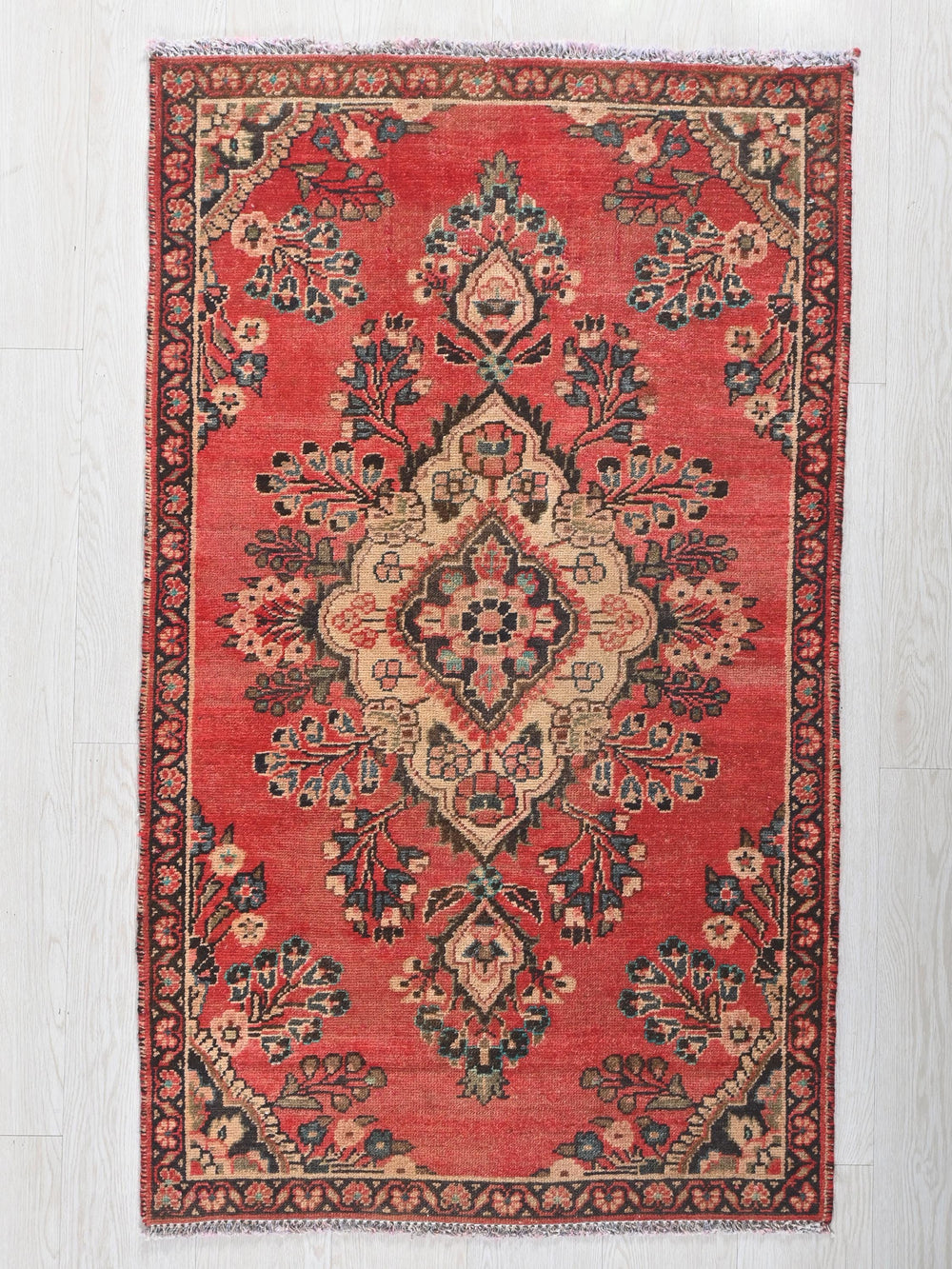 a red rug with a floral design on it