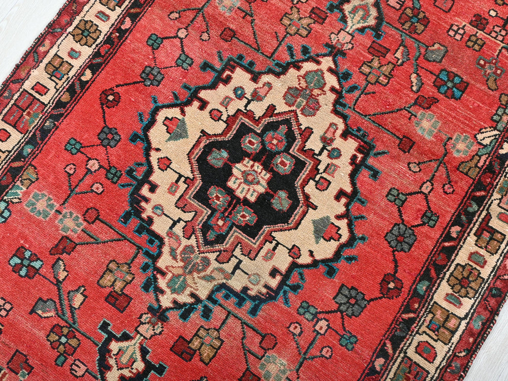 a red rug with a black and white design