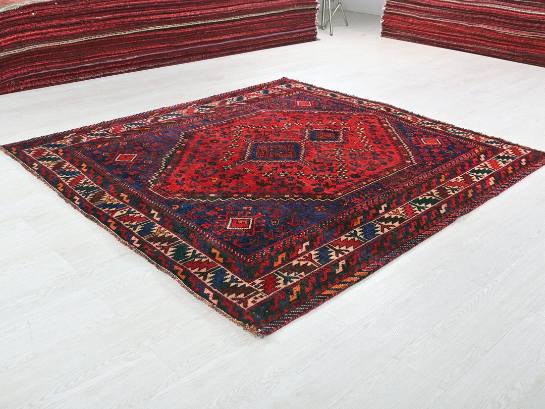 a red and blue rug sitting on top of a white floor