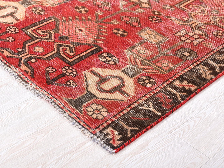 a red oriental rug on a white wooden floor