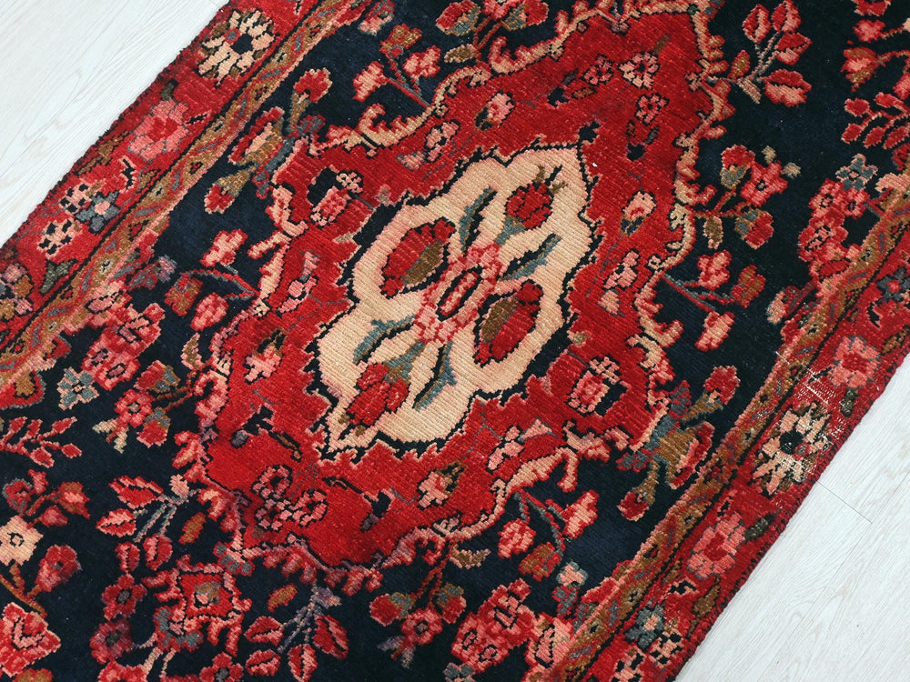 a red and black oriental rug on a white floor