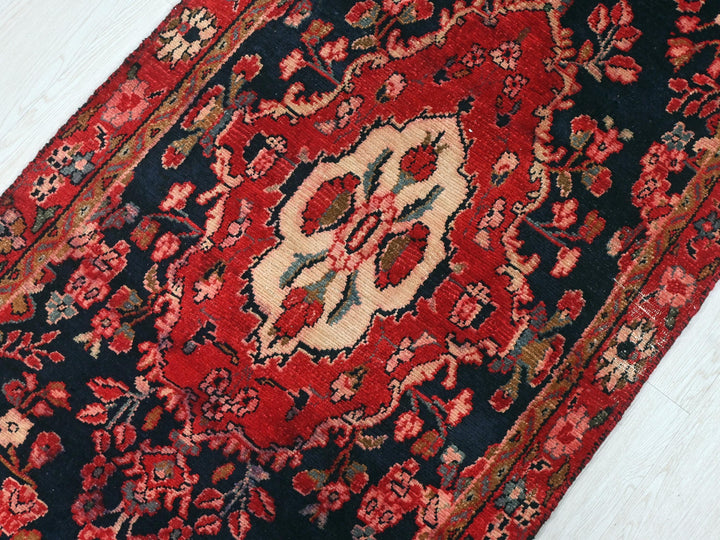 a red and black oriental rug on a white floor