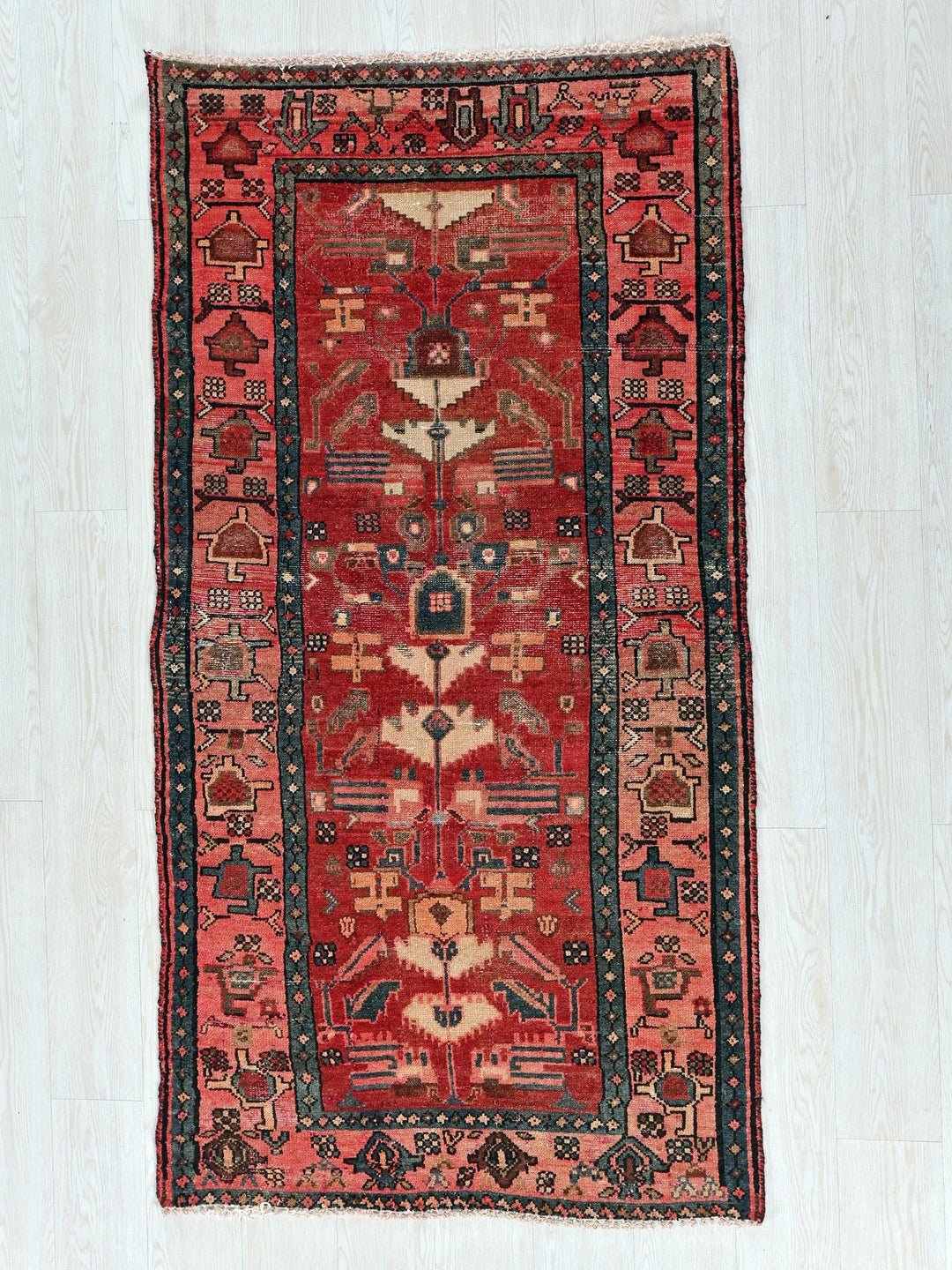 a red and black rug on a white floor