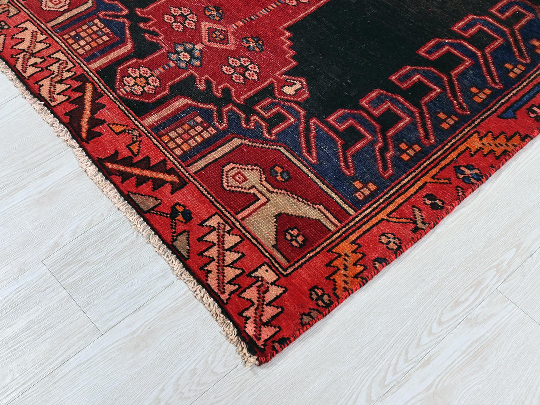 a red rug with a black border on a white floor