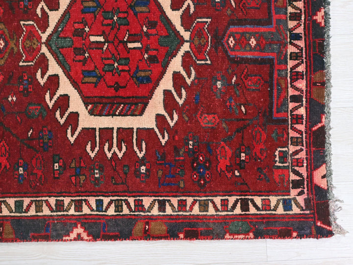 a red oriental rug on a white wooden floor