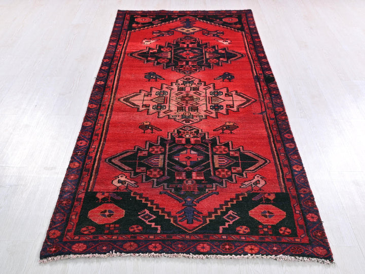 a red and black rug on a white floor