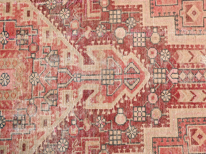 a red and beige rug with a pattern on it
