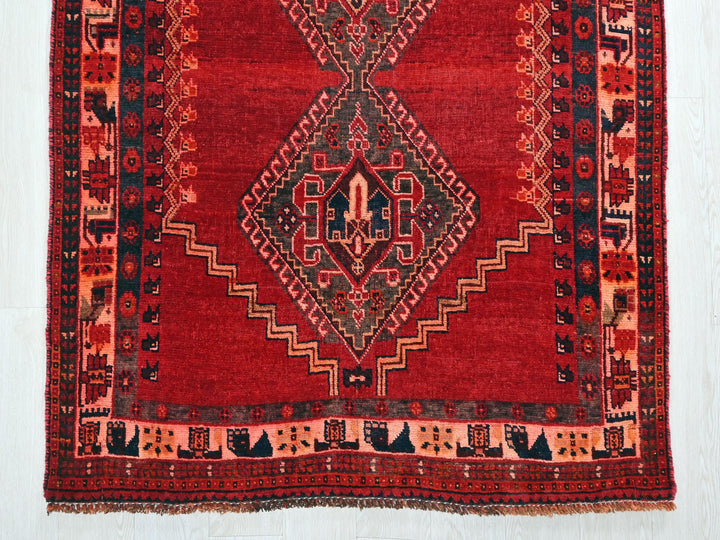 a red rug with a design on the middle of it