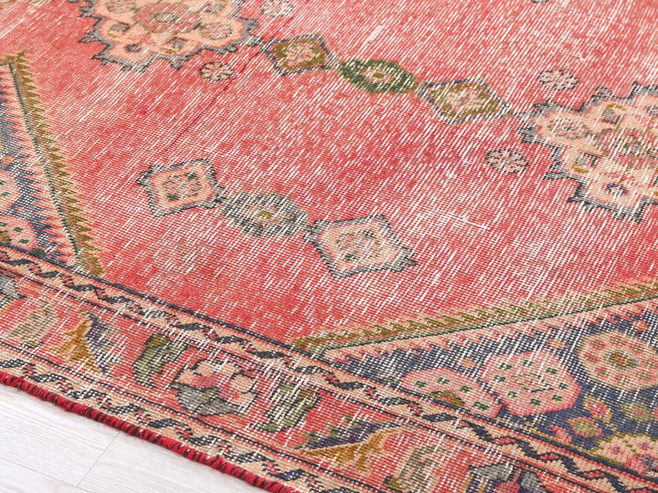 a red rug with a floral design on it