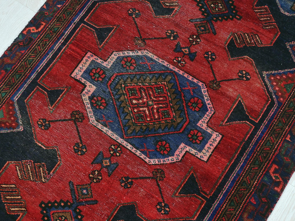 a red rug with a design on the middle of it