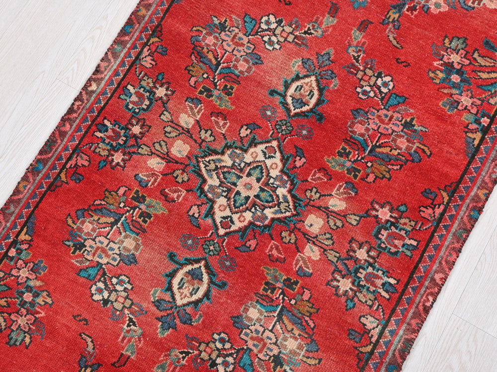 a red rug on a white wooden floor