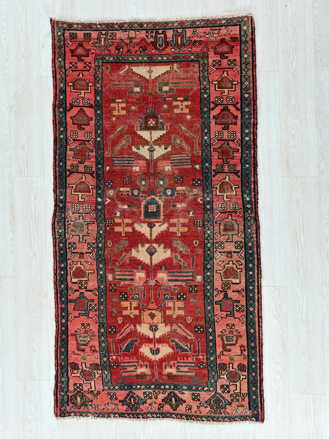 a red and black rug on a white floor
