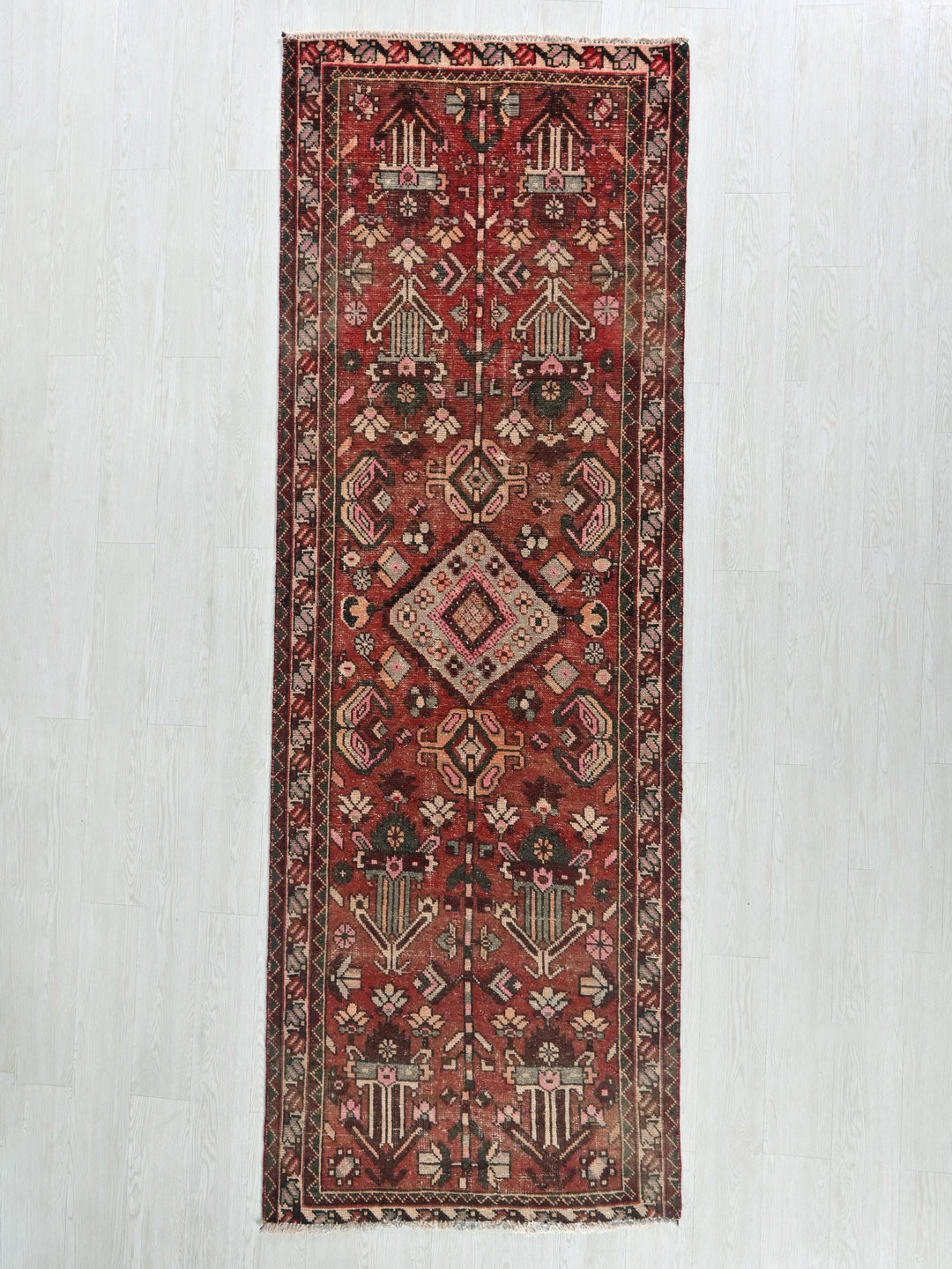 a red oriental rug hanging on a wall