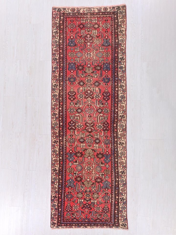 a red rug with a design on the middle of it