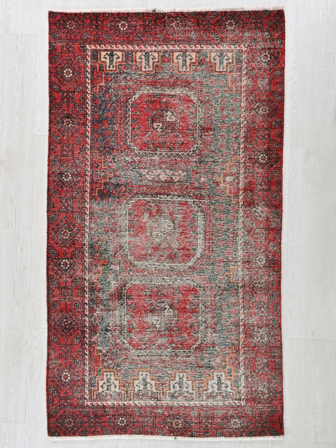 a red rug with a design on the middle of it