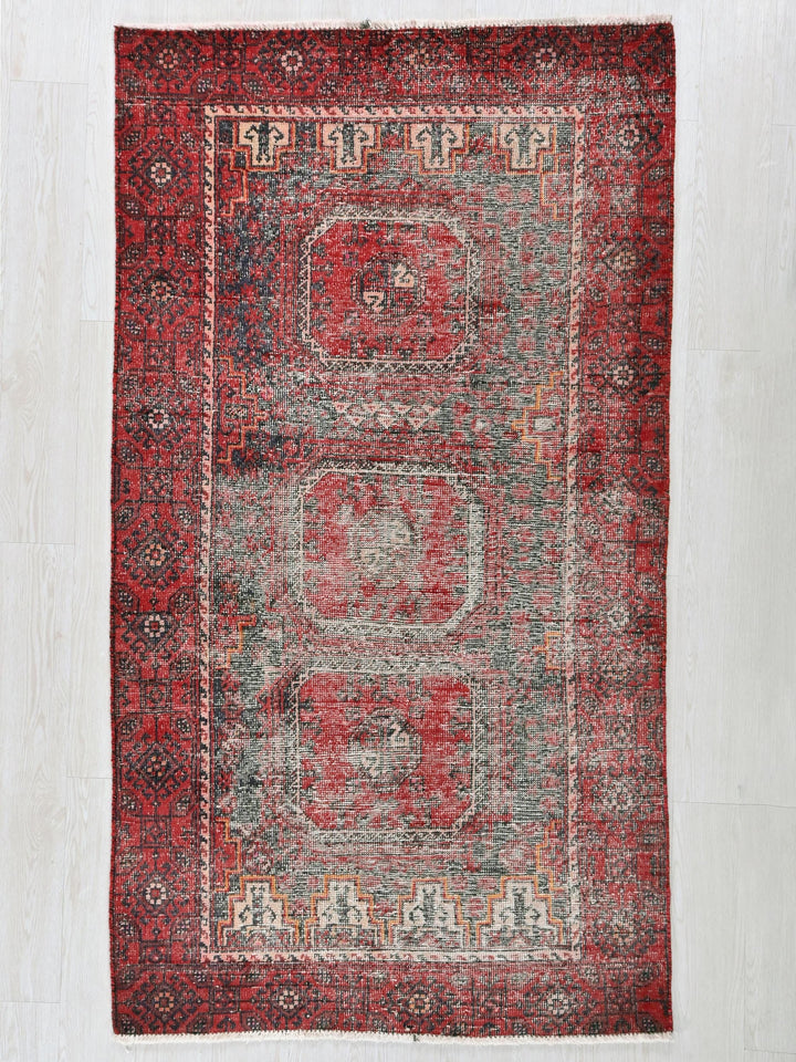 a red rug with a design on the middle of it