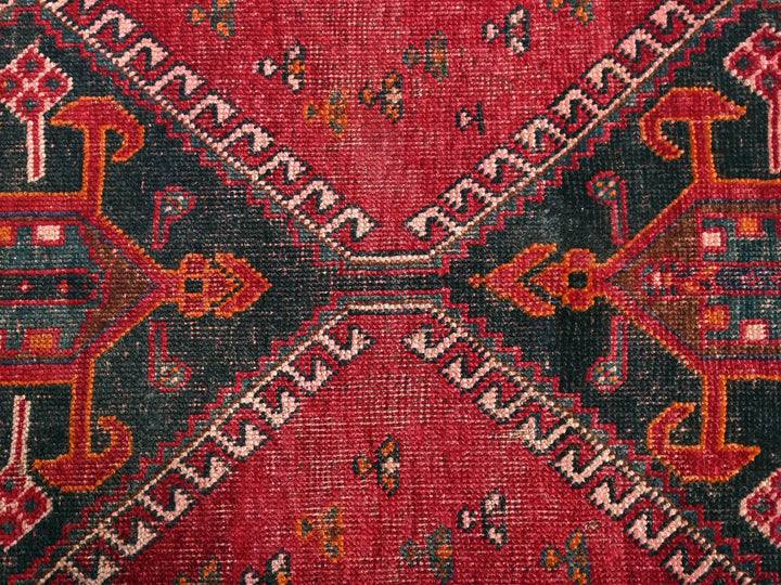 a close up of a red rug with a design on it