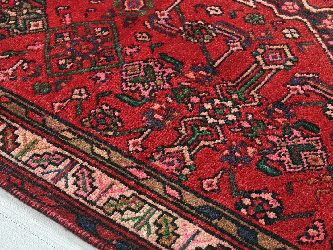 a close up of a red rug on a white floor