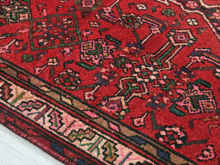 a close up of a red rug on a white floor