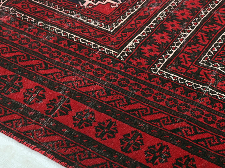 a close up of a red rug on a white surface