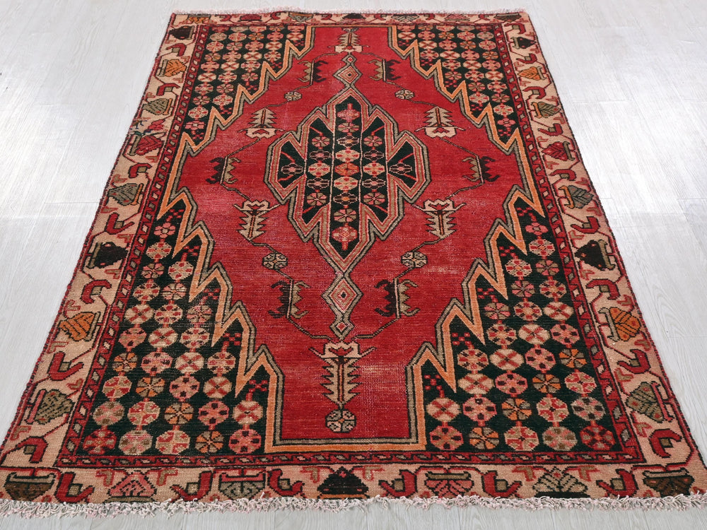 a red and black rug on a white floor